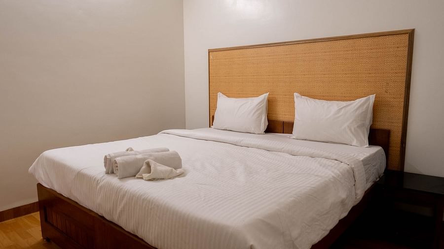 Side veiw of a bed with towels at 1 bhk Deluxe Studio Apartment, Vistar Holidays, Goa.