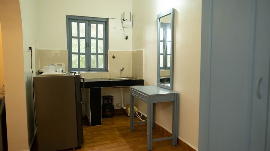 Image of a kitchen with fridge and table at at 1 bhk Deluxe Studio Apartment, Vistar Holidays, Goa.