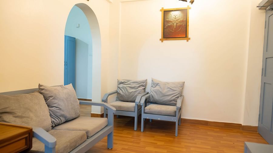 Image of a seating room with a frame on the wall and an arched doorway on the side at the 1 bhk Deluxe Studio Apartment, Vistar Holidays, Goa.