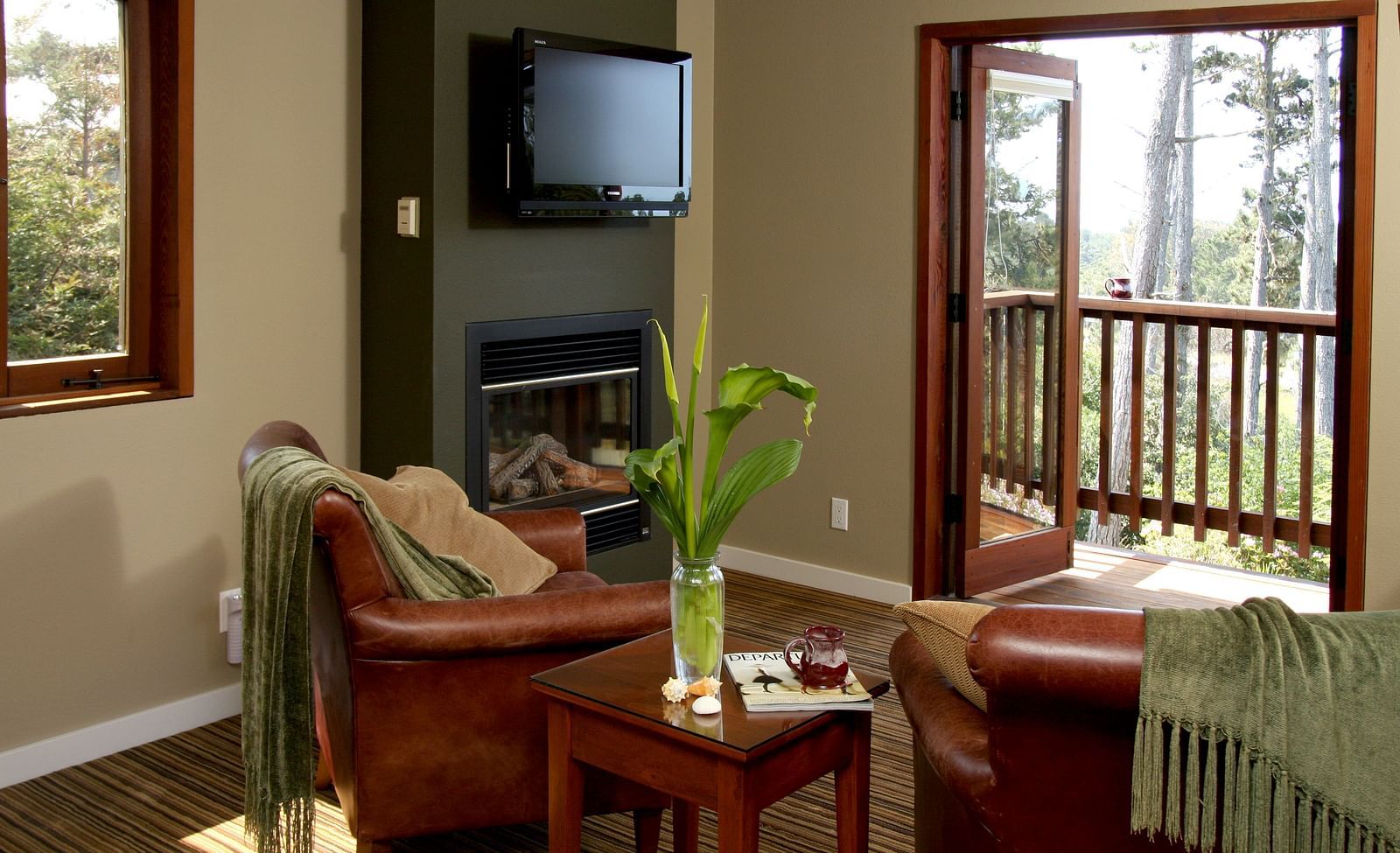 A corner in one of rooms featuring a fireplace, wooden accents, a teapoy, and couches - Brewery Gulch Inn & Spa