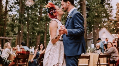 Couple sharing a romantic dance during an outdoor forest wedding ceremony at Shaver lake Village Hotel.
