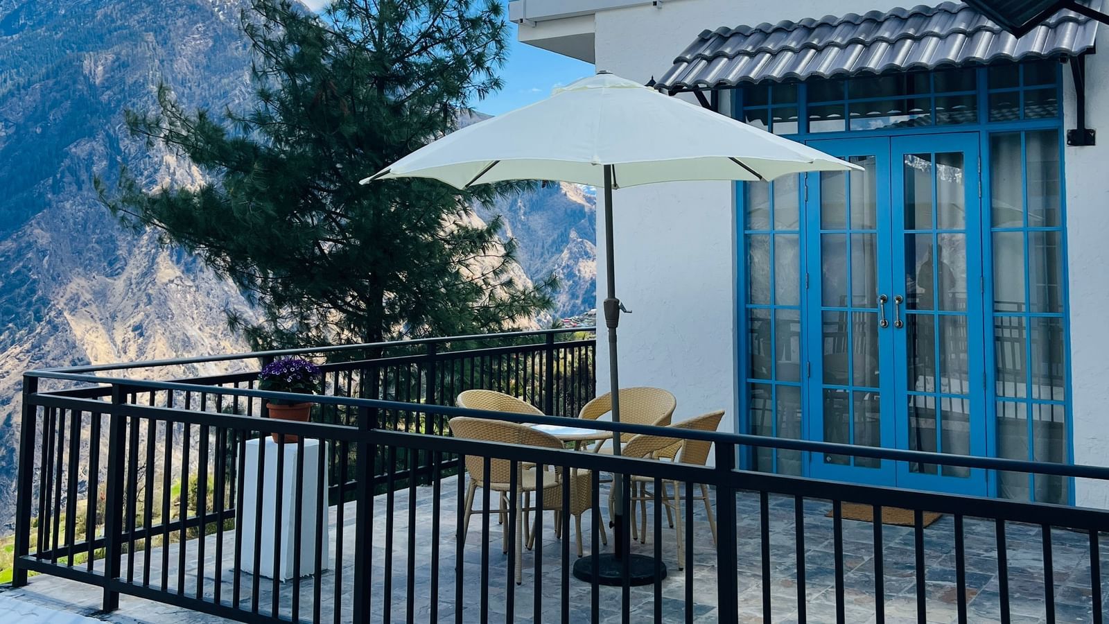 Outdoor seating area with umbrella and mountain views at Faraway Cottages, Auli.