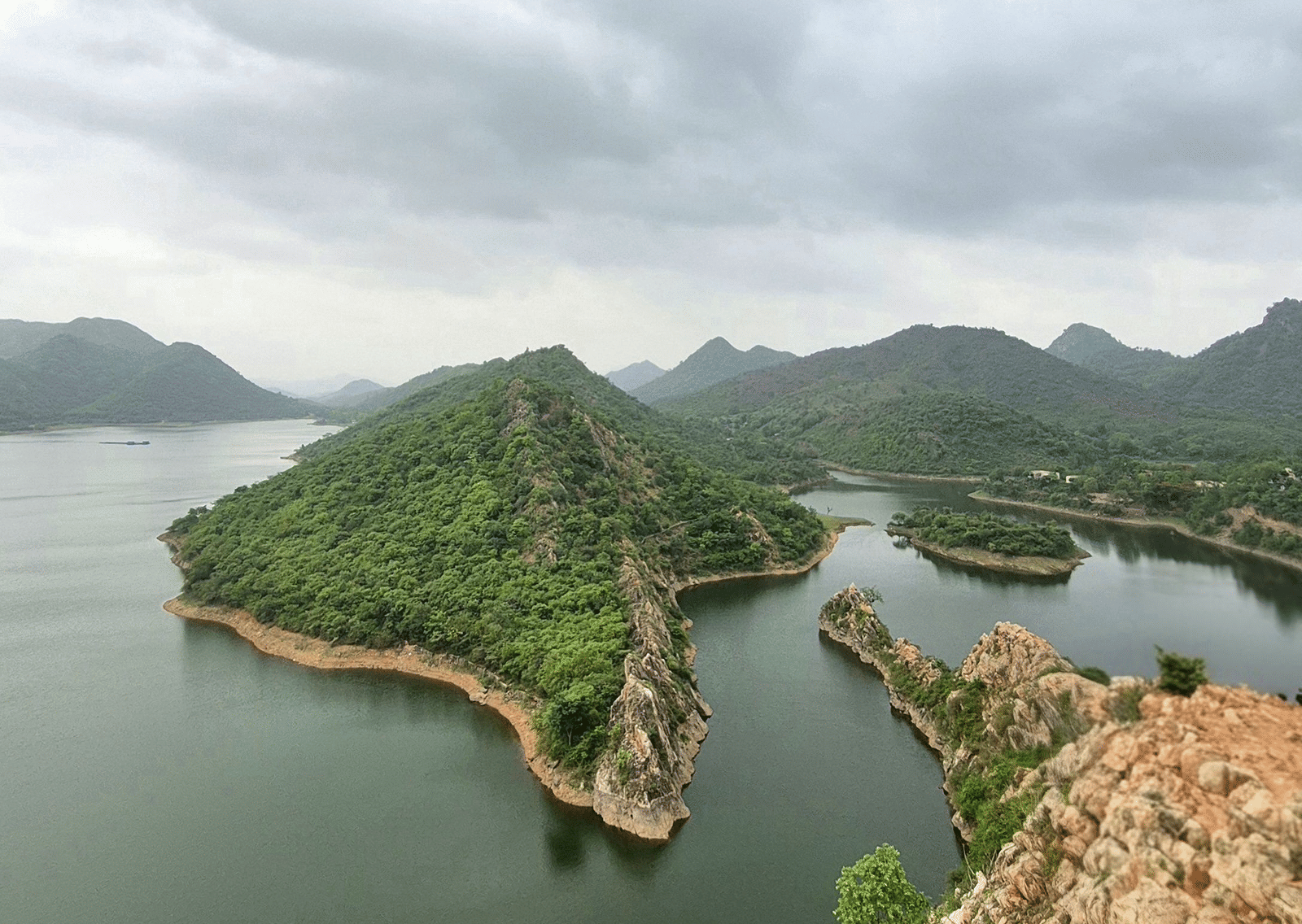 Vertical view of Bahubali Hills over Badi Lake under an overcast sky.