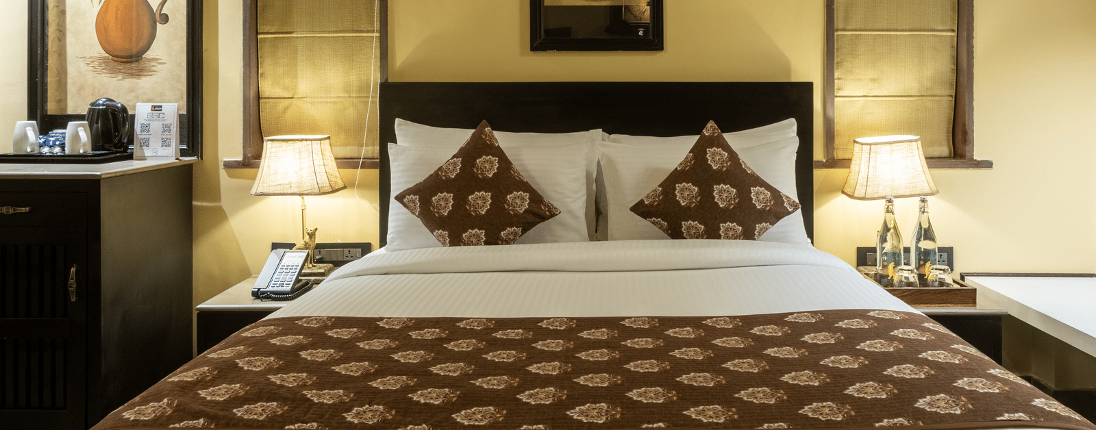 A stylish bedroom at Aamaghati Wildlife Resort featuring chic décor, warm tones, and modern furnishings for a restful experience.