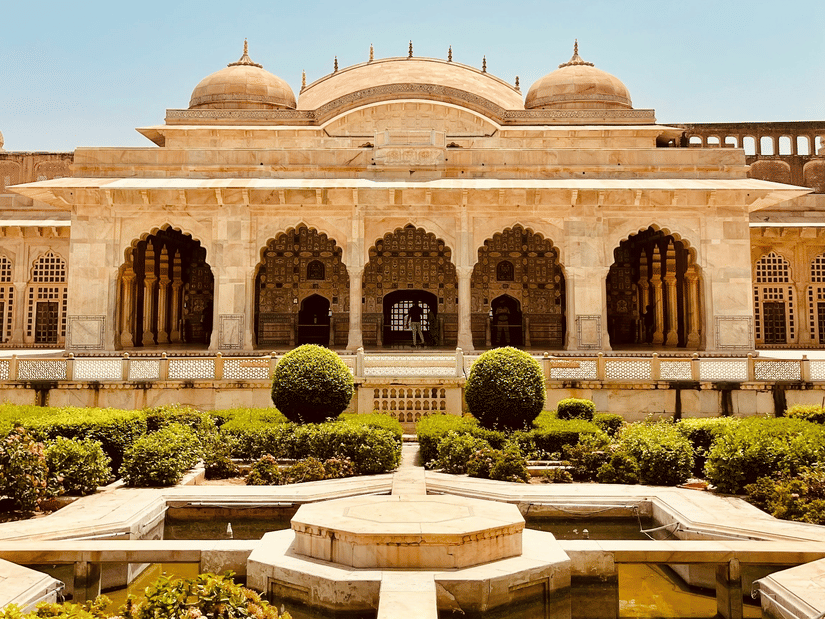 Amber Fort under a clear sky featuring a fountain surrounded by manicured garden