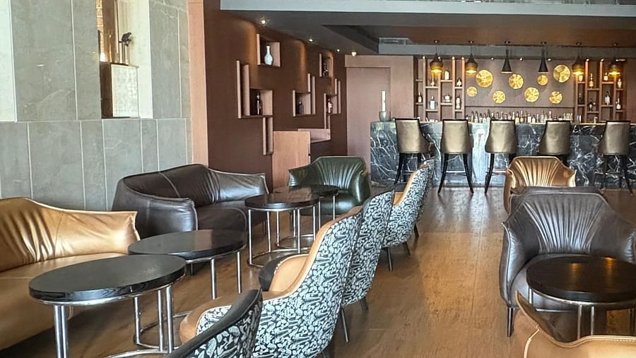 A long shot of a bar with a geometric chandelier, emphasizing the space and perspective from a different angle.