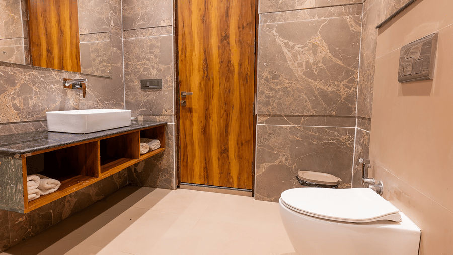 Elegant bathroom with wooden doors, vanity, and shower at Silver Sand Sea Princess Beach Resort, Port Blair.
