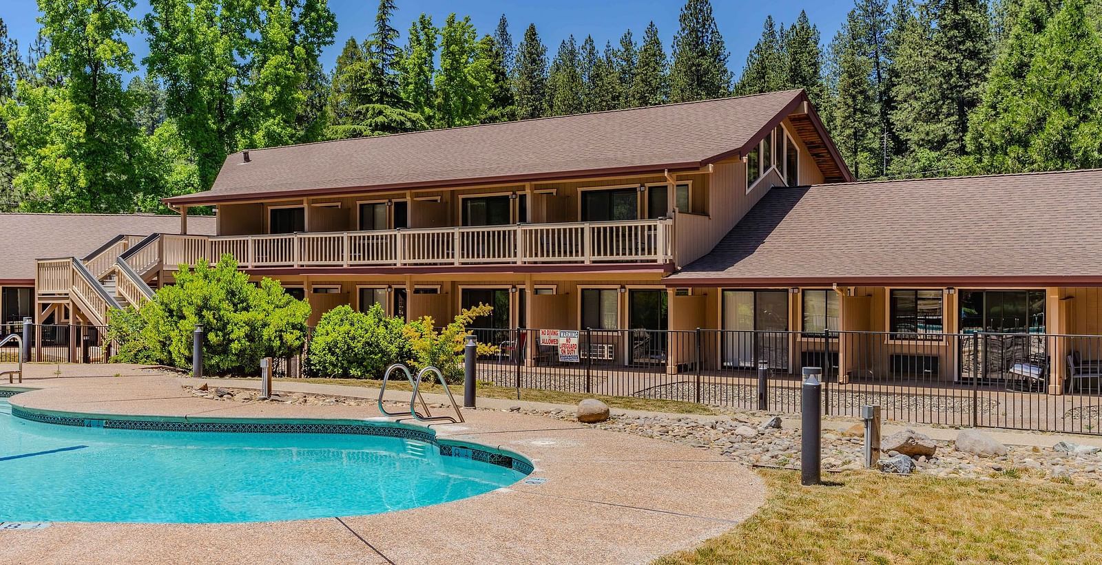 A view of an outdoor swimming pool with a cabin in the backdrop