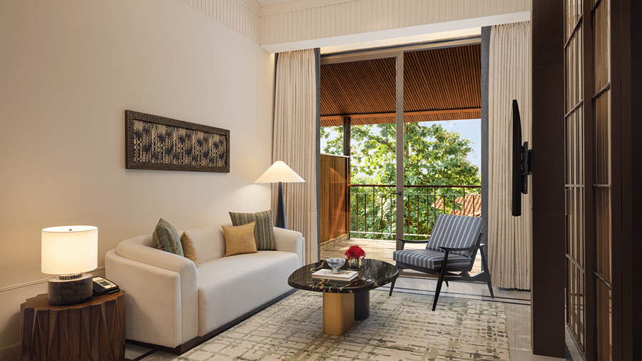 Living area of the Sanctuary Suite at The Riverview Retreat, Corbett, with a sofa, lounge chair and floor-to-ceiling windows.