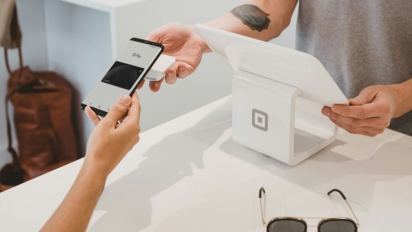 An overview of a person paying for an item at a shop using their phone.