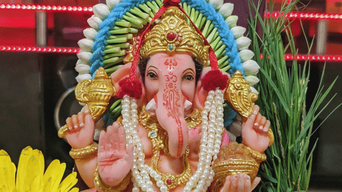 Ganesha idol decorated with flowers and greenery, displayed beneath a colourful canopy during a festive Vinayaka Chaturthi celebration in Chennai