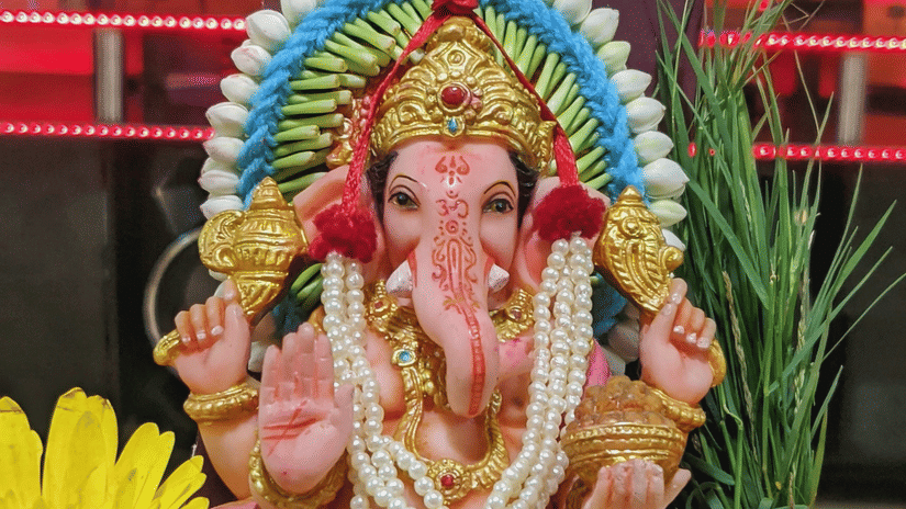 Ganesha idol decorated with flowers and greenery, displayed beneath a colourful canopy during a festive Vinayaka Chaturthi celebration in Chennai