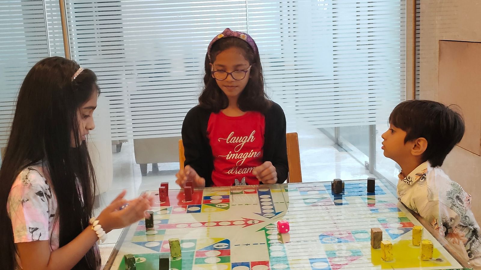 A shot of three kids playing board games at the game zone of the resort | The Grand Legacy Resort and Spa