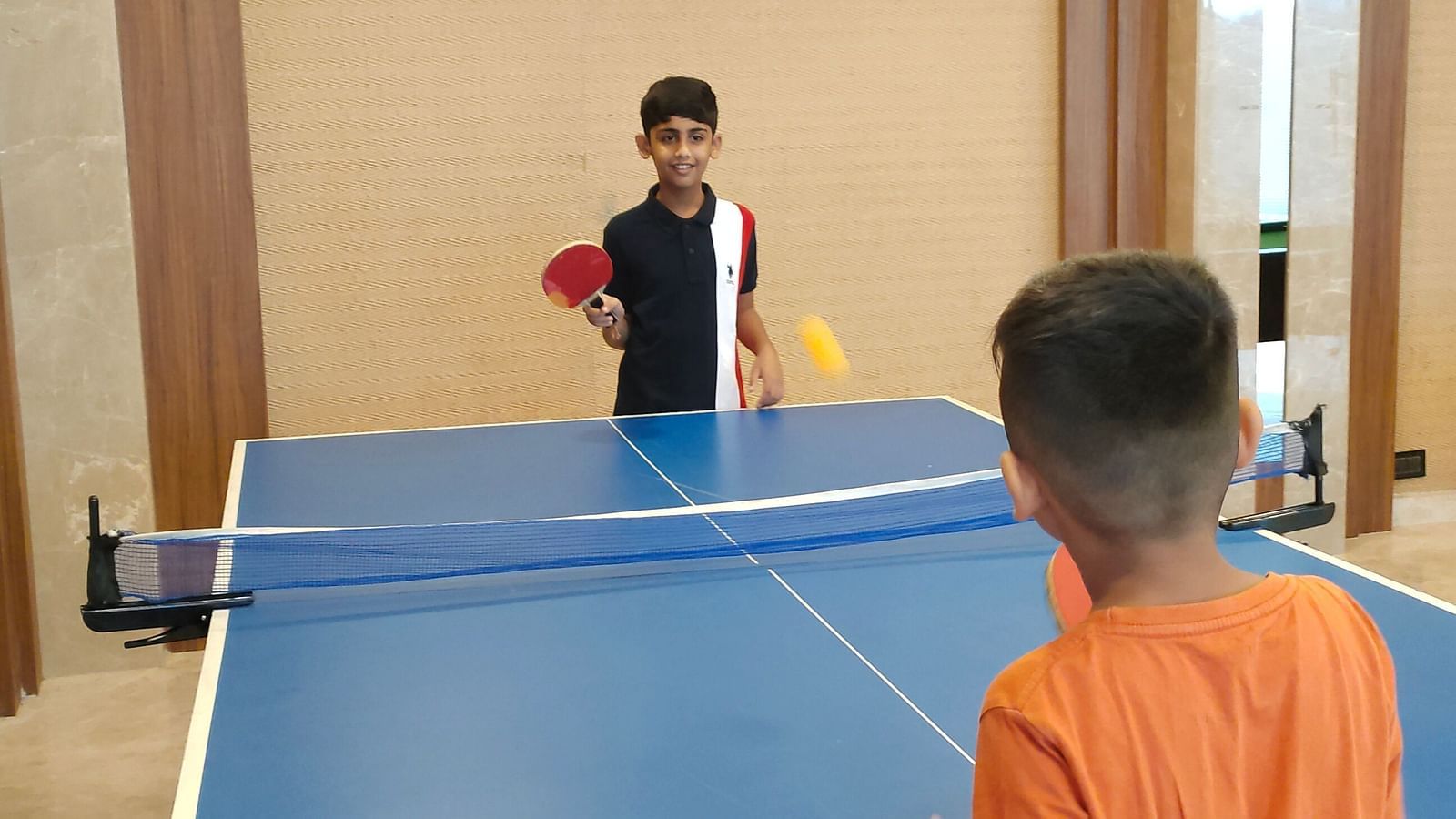 Image of two kids playing table tennis inside the game zone at the resort | The Grand Legacy Resort and Spa