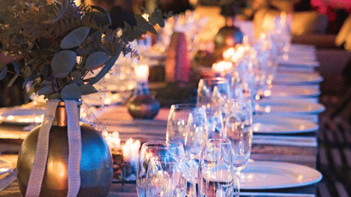 A dining table with plates and glasses neatly lined