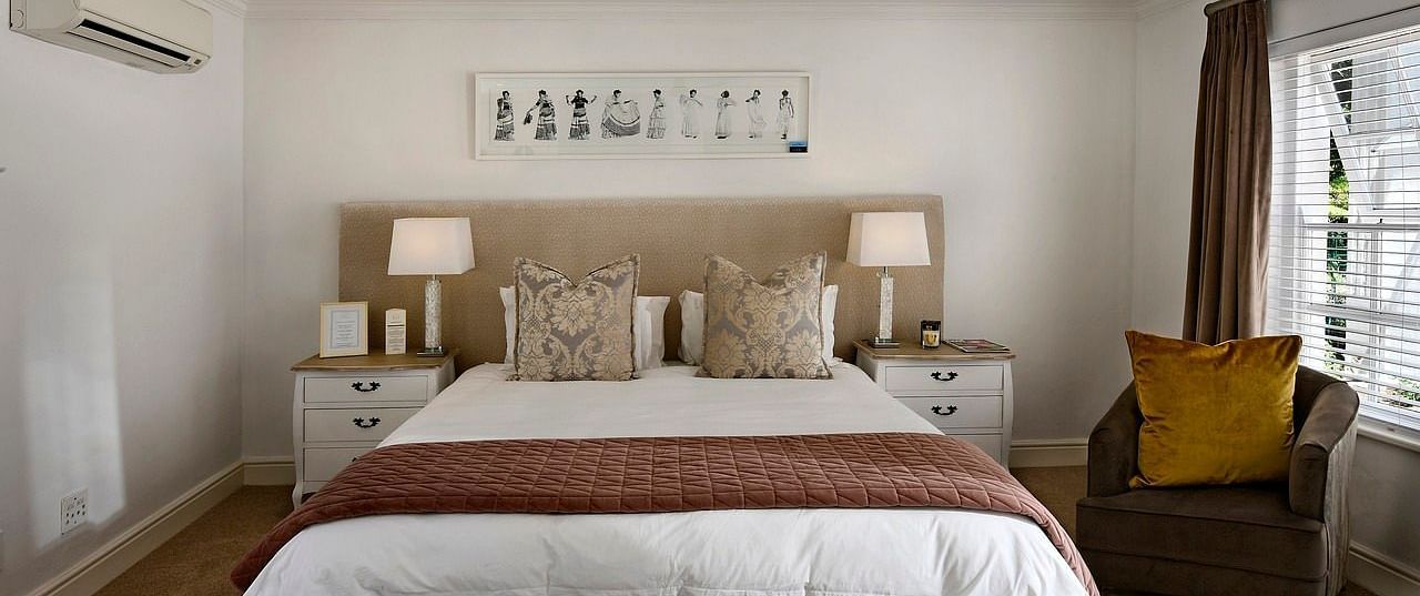 A double bed with a ceiling fan hanging over it in a bedroom.