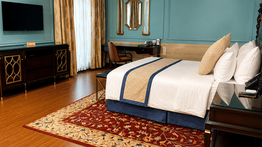 Junior Suite bedroom with teal accent walls and wooden flooring at MAYFAIR Lake Resort, Raipur