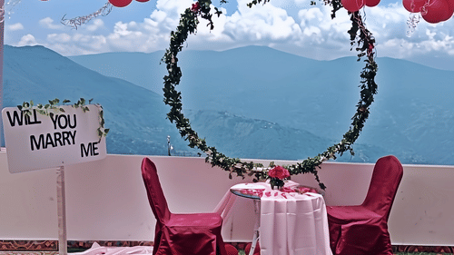 Romantic outdoor setup with mountain view at Mount View Haven, featuring decorated chairs and a circular floral arch