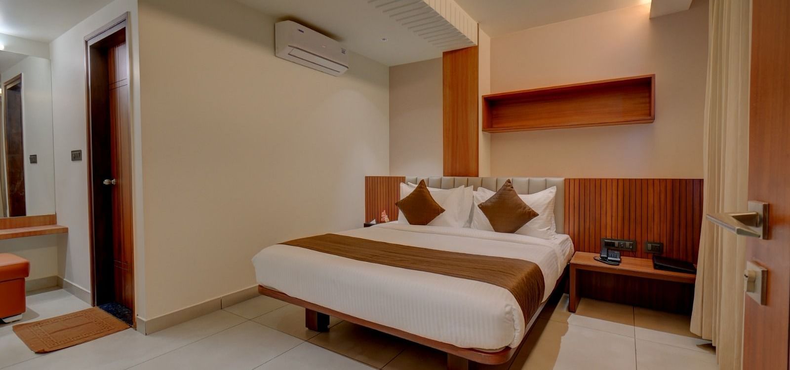 An image of a room at Hari Govindas, Siddappa Square, featuring a bed with a door on the side.