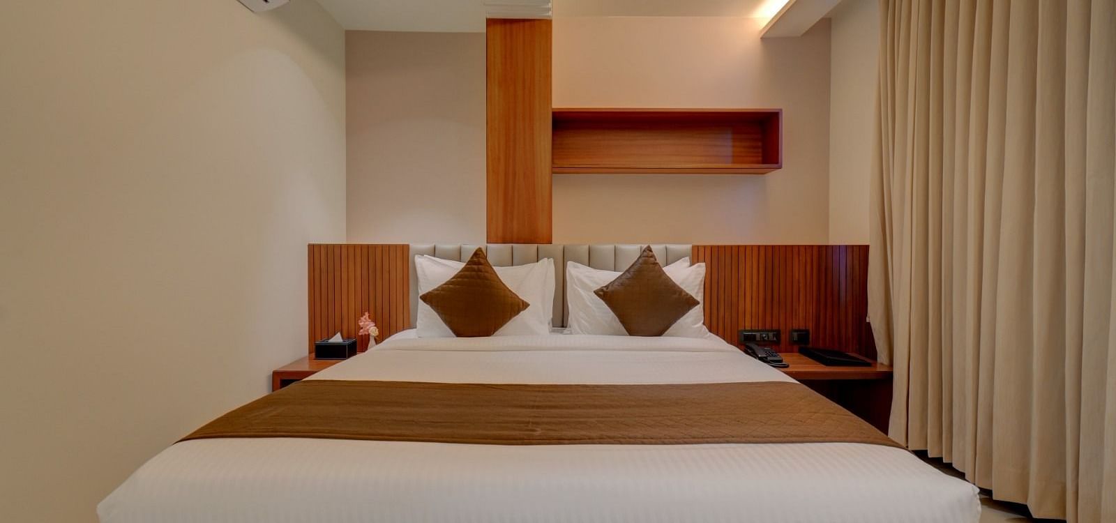 An image of a room at Hari Govindas, Siddappa Square, featuring a bed with a window on the side.