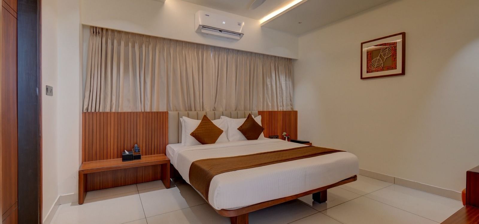 An image of a room at Hari Govindas, Siddappa Square, featuring a bed with an air conditioner mounted above it.