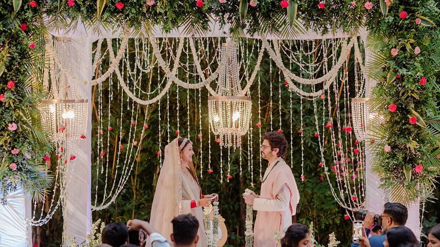 A couple exchanging vows under a floral archway at a wedding ceremony.