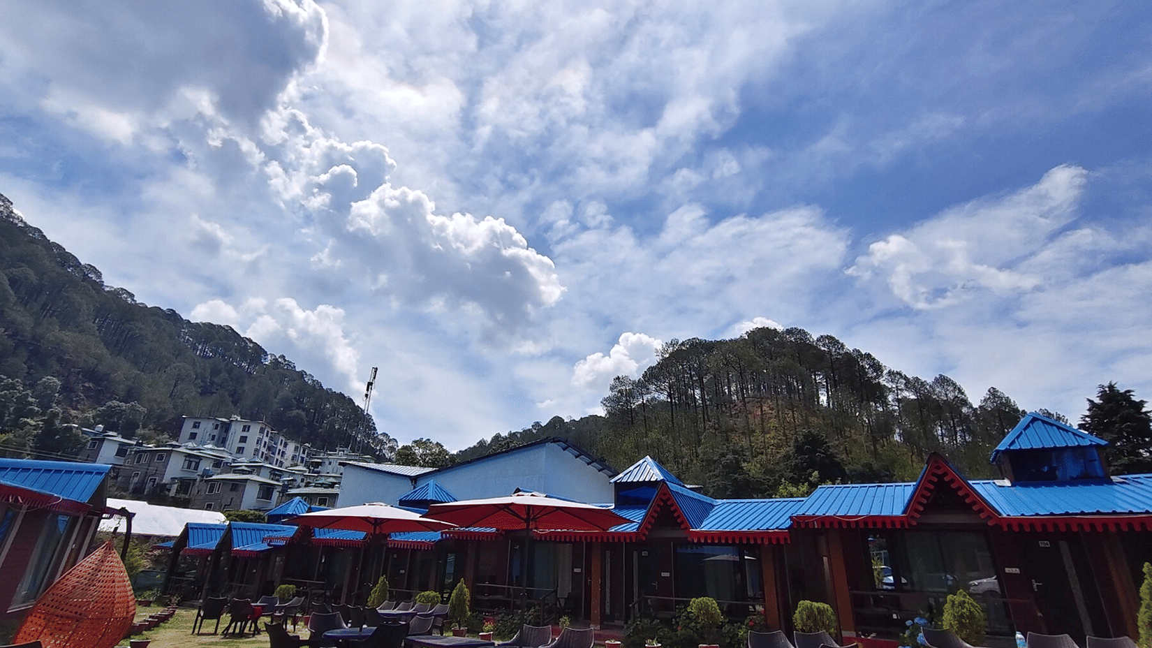 Sol Glow Resort cottages with blue roofs and open lawn near Kainchi Dham, Bhowali