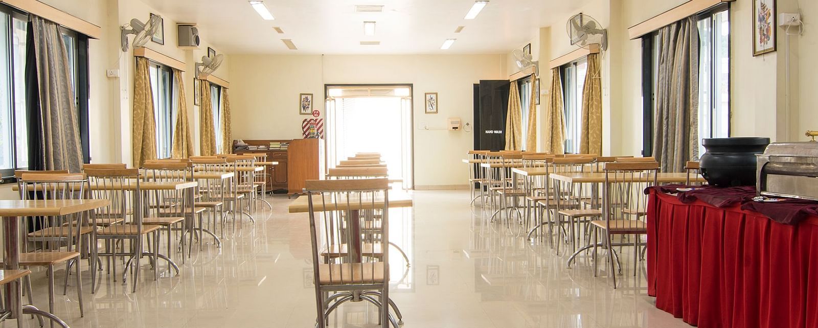 The first conference room image, depicting the arranged seating and podium with a red cloth at Shantiniketan - Budget Stay in Hyderabad near Ramoji Film City.