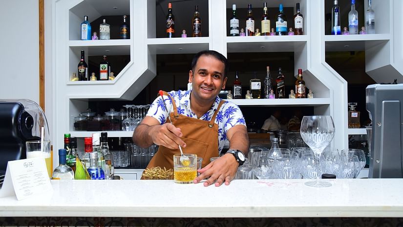 A bartender preparing a cocktail at the bar in Cloud9 Sarovar Premiere, Palolem Goa, with various other drinks visible in the background.