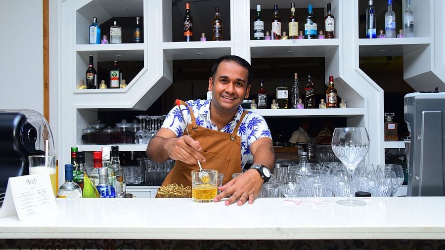 A bartender preparing a cocktail at the bar in Cloud9 Sarovar Premiere, Palolem Goa, with various other drinks visible in the background.