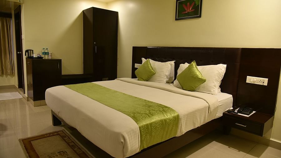 Room with bed, wardrobe and side table at Hotel Green Apple