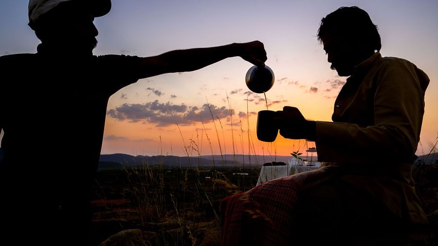 An image of a two men where one is pouring tea for the other in a cup - Utsav Camp Sariska