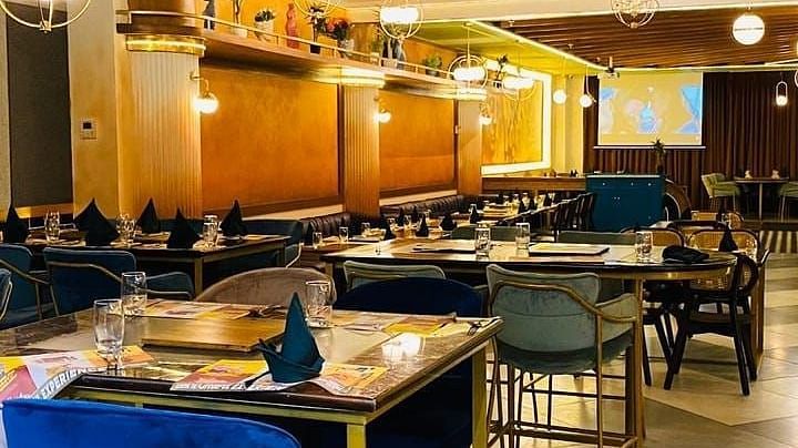 An image of a restaurant at featuring chairs, counter table, and a shelf behind - Themis Barbecue House, Panipat