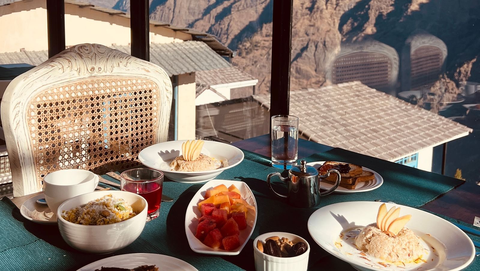 Image of a variety of food on a table and veiws of the mountian | Faraway Cottages, Auli