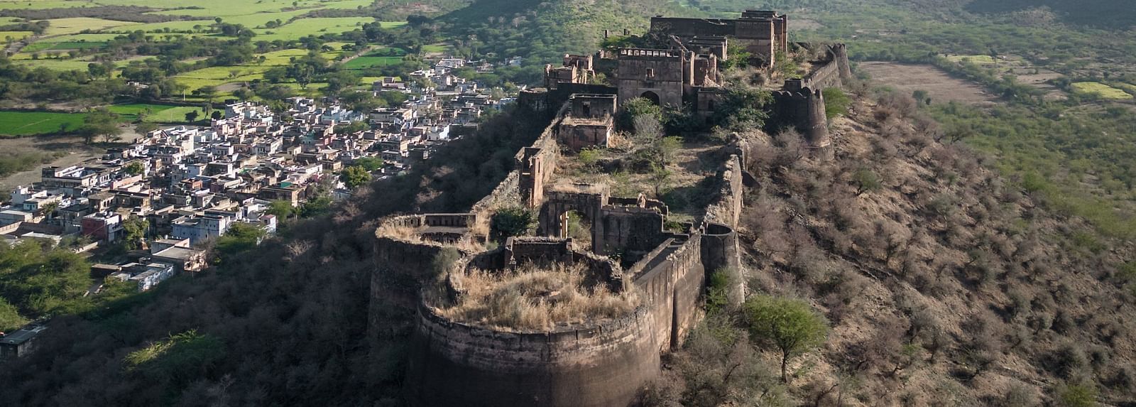 An aerial image of a fort with the backdrop of mountains