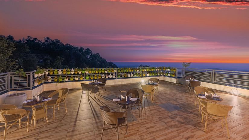 seating arrangements on the terrace with different hues in the sky after the sunset - Stone Wood Mountain Resort, Dharamshala
