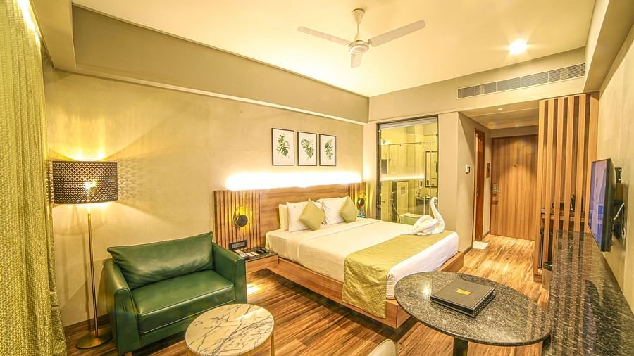 A double bed and a sofa in the Premium Balcony Room at Grand Palace, Yercaud