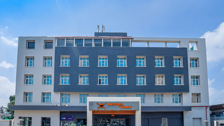 A front view of a hotel building with the name of the hotel mentioned on a signage - Max Hotel Prayagraj