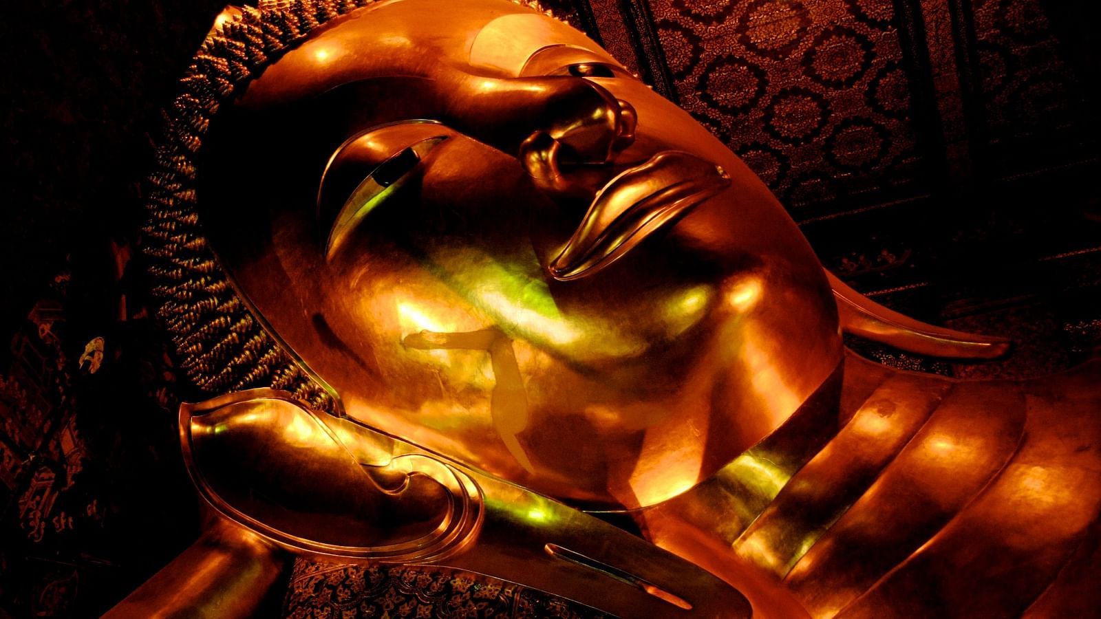 an image of The Reclining Buddha of Wat Pho offering a golden glow