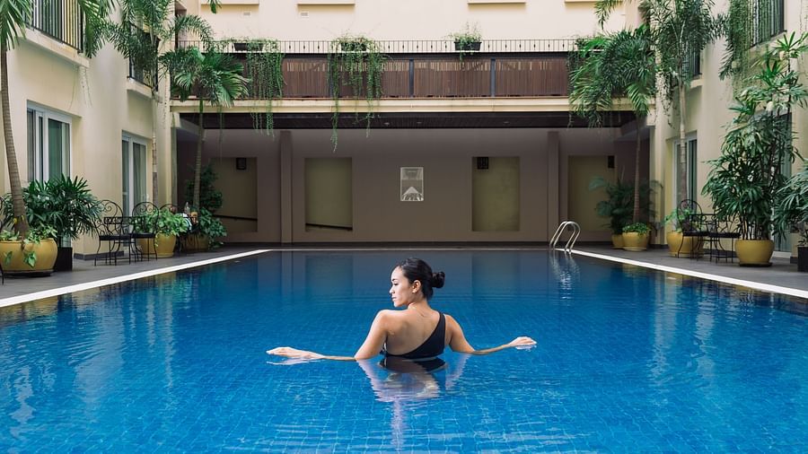 A person is floating in a swimming pool, enjoying a relaxing moment in the water | Central Mansions, Phnom Penh