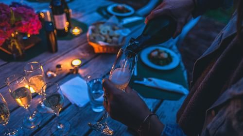person pouring alcohol in a glass