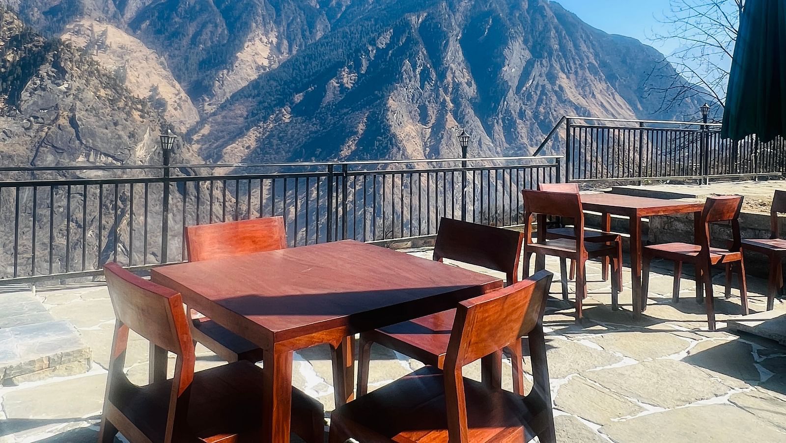 Image of a dining space in a balcony with views of the mountains in the background | Faraway Cottages, Auli