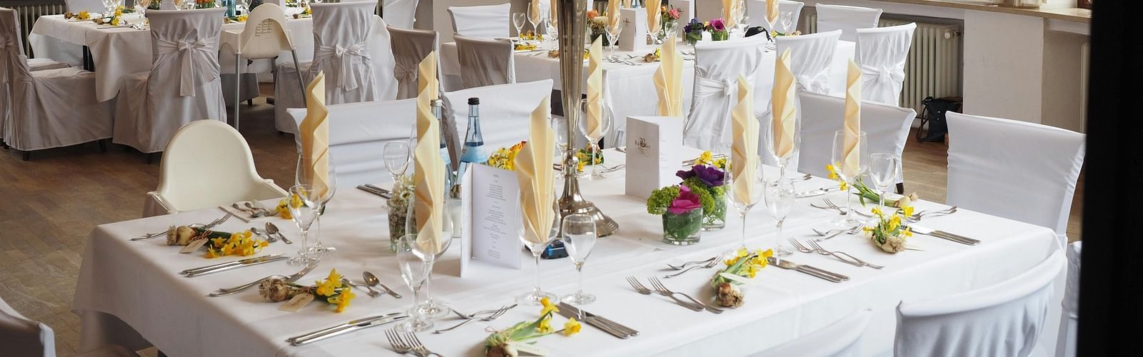 A restaurant depicting seating arrangement with cutlery and decorative items on the table