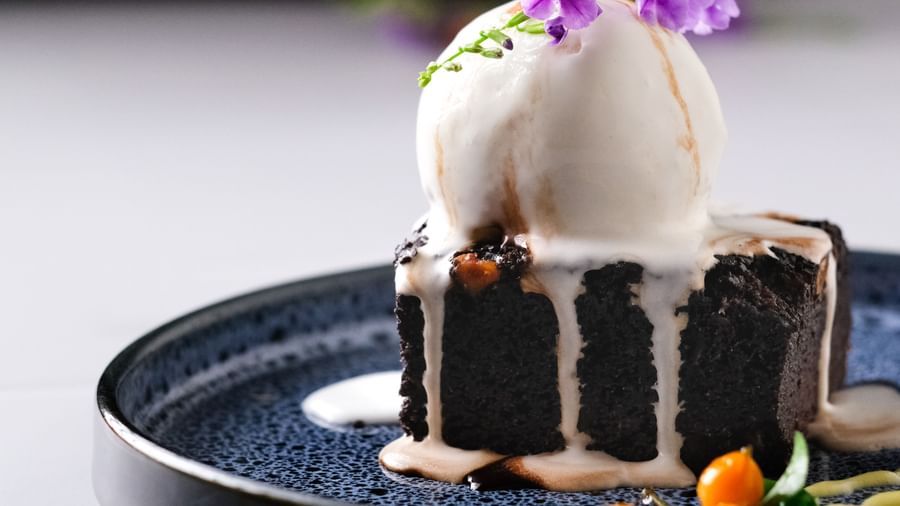 Chocolate cake topped with ice cream and edible flowers | Mango Hill, Pondicherry