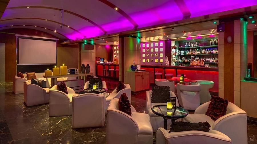 Chic lounge bar with vibrant lighting, plush seating, and a well-stocked bar – Hotel Hindusthan International, Kolkata.