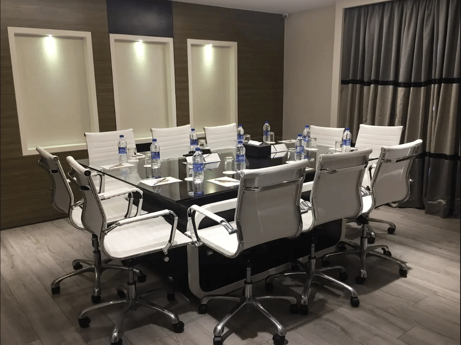 A boardroom at Adamo Empressa with official chairs and a table.