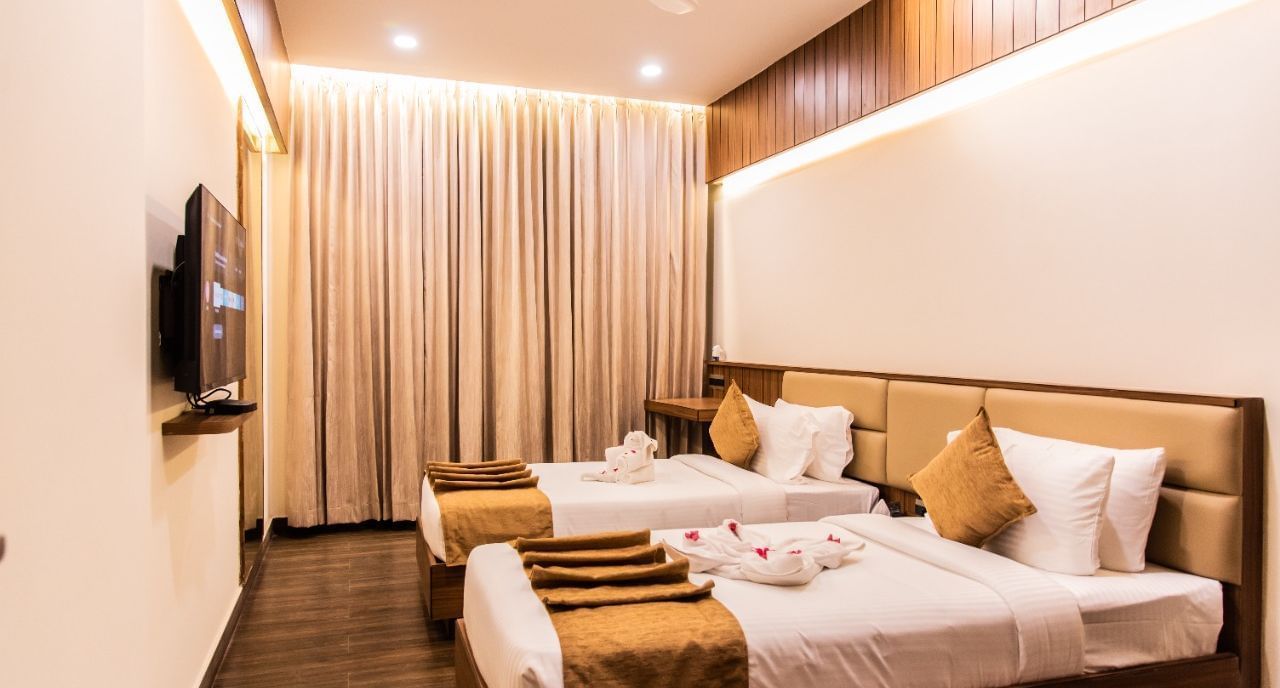 Executive room with two beds and television at TGI Felicity