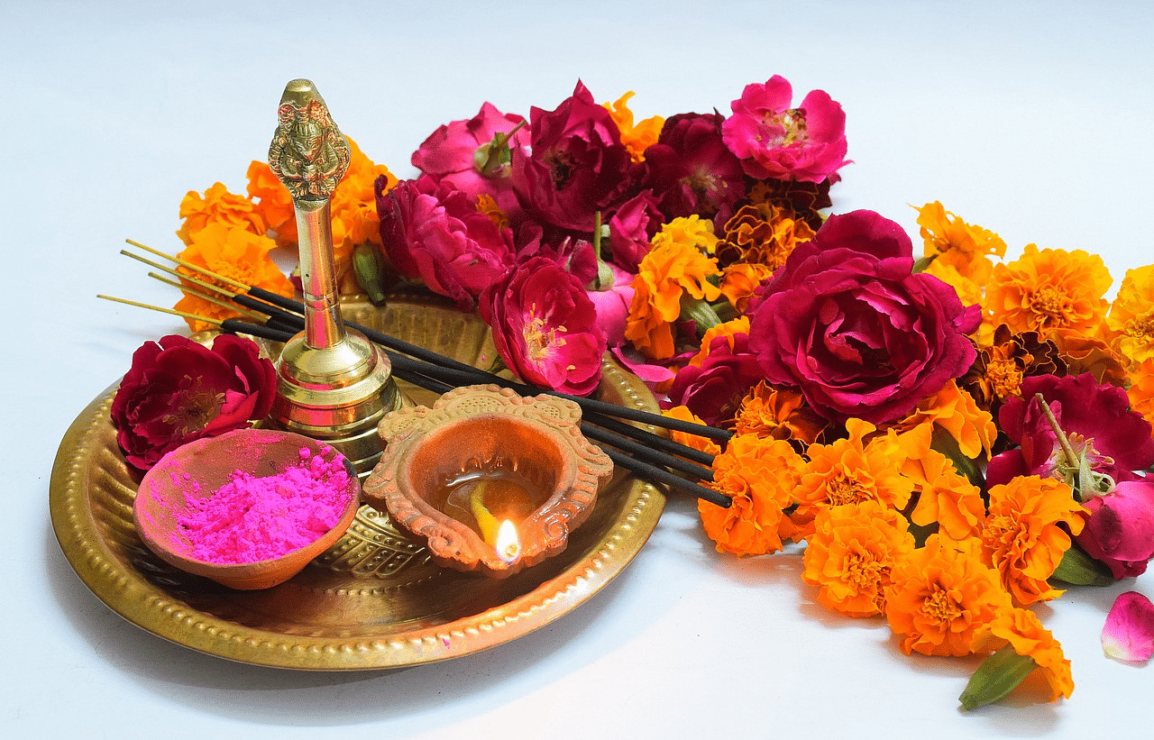 An image of  a plate with flowers and diya used for aarti