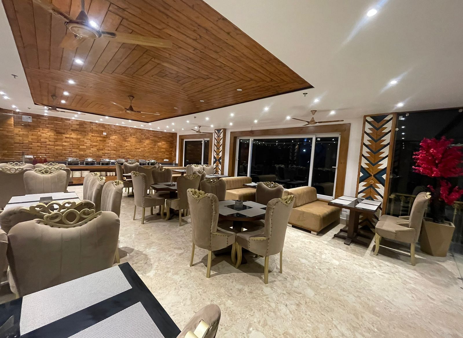 Dining area with comfortable chairs around tables at Rainbow Restaurant at DLS Ark Holiday Inn, Banikhet.