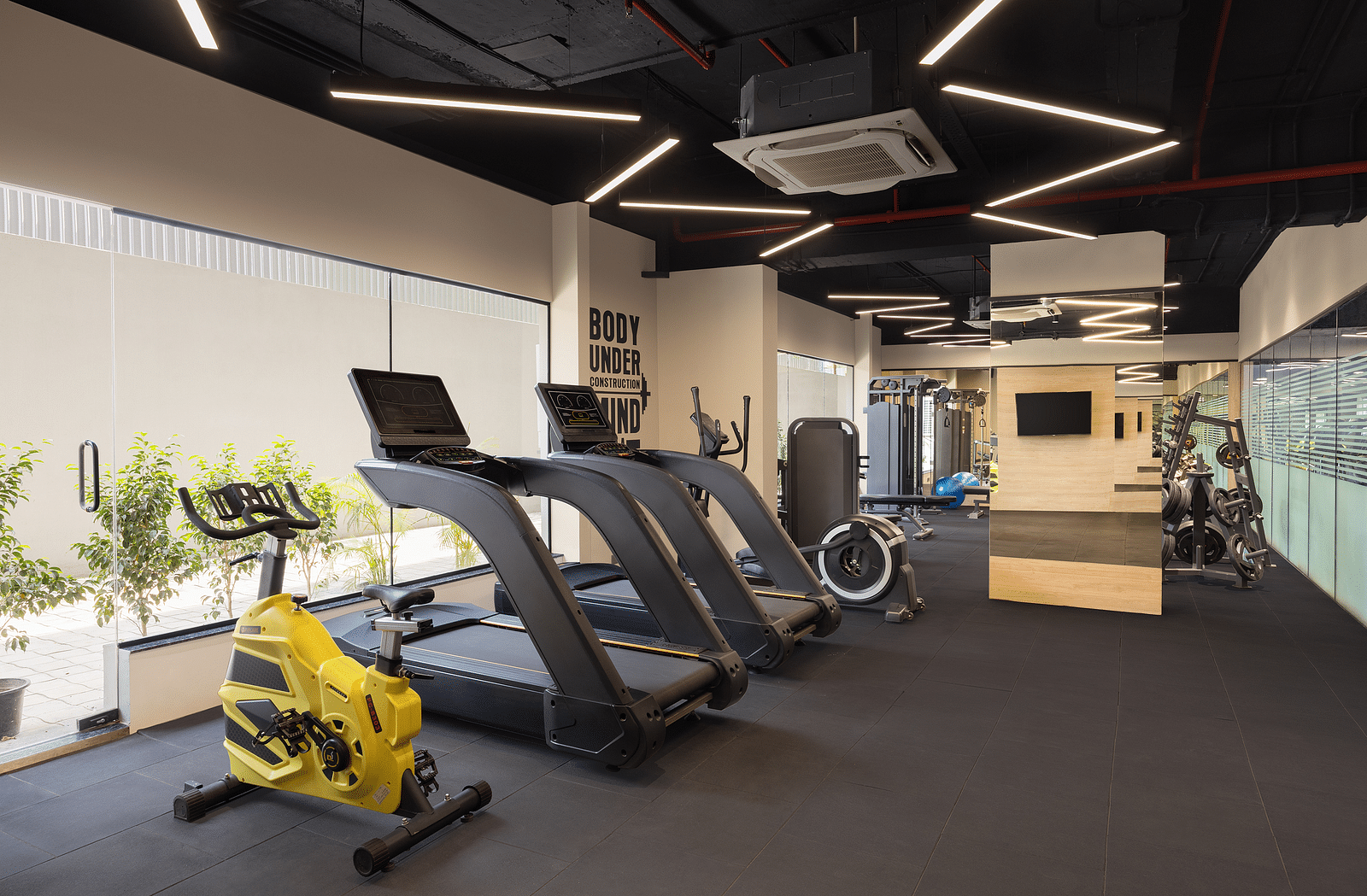 Gym at Essentia Luxury Hotel, Indore with cardio equipment placed near the windows